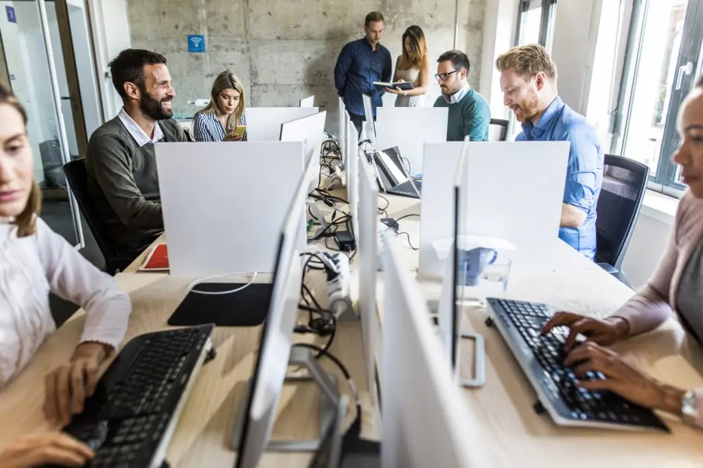 Professionals working at computers in a modern office setting.