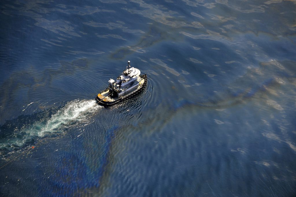 An emergency boat is responding to an offshore oil spill.