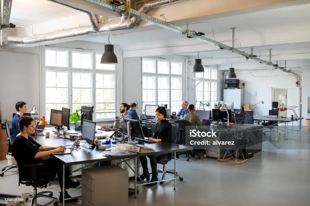 Office workers engaged in their tasks in a modern, bright workspace.