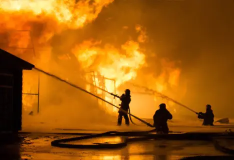 Firefighters battling a large blaze at night.